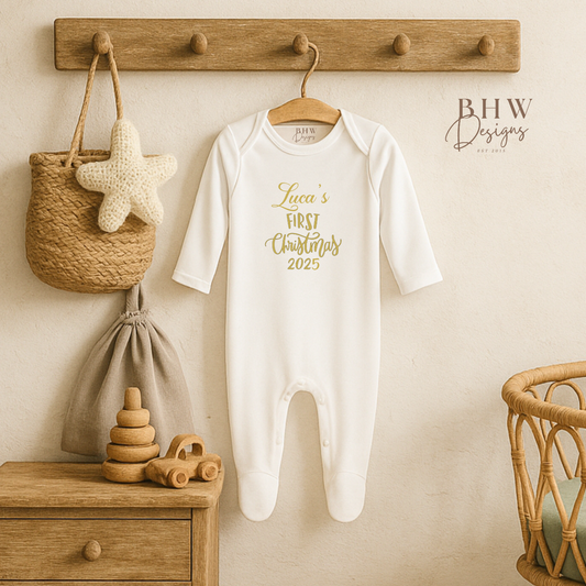 Baby onesie with 'Luca's First Christmas 2025' text hanging on a wooden peg rack with toys below.