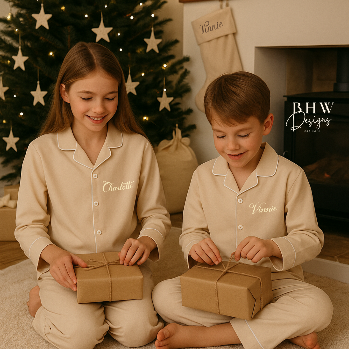 Boy and girl in matching beige cotton pyjamas Personalised with names in cream opening christmas gifts