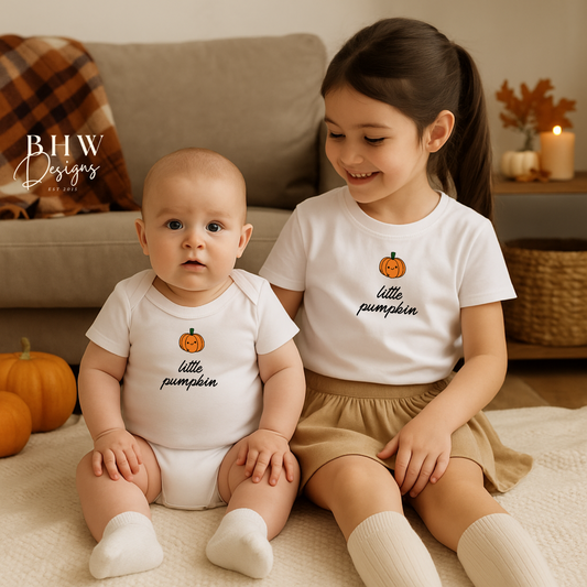 Two children wearing 'little pumpkin' outfits sitting on a couch with pumpkins around.