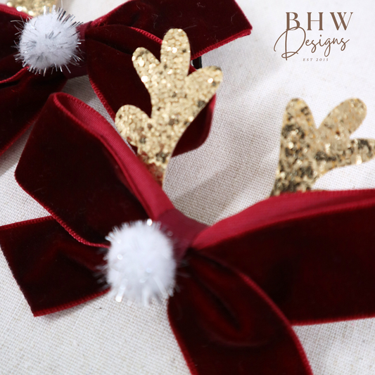 Red velvet hair bow with gold antlers and white pom-poms