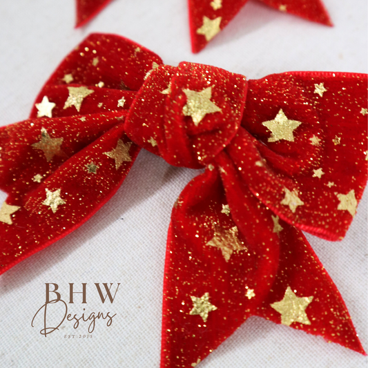Red glittery bows with gold stars on a white background,