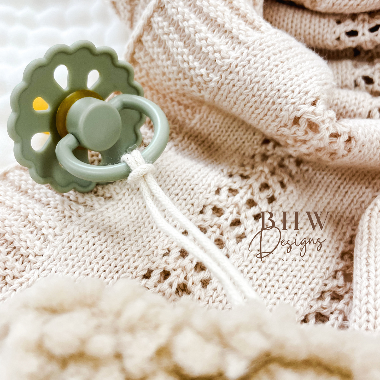 Close up of the dummy clip attached to a sage green dummy