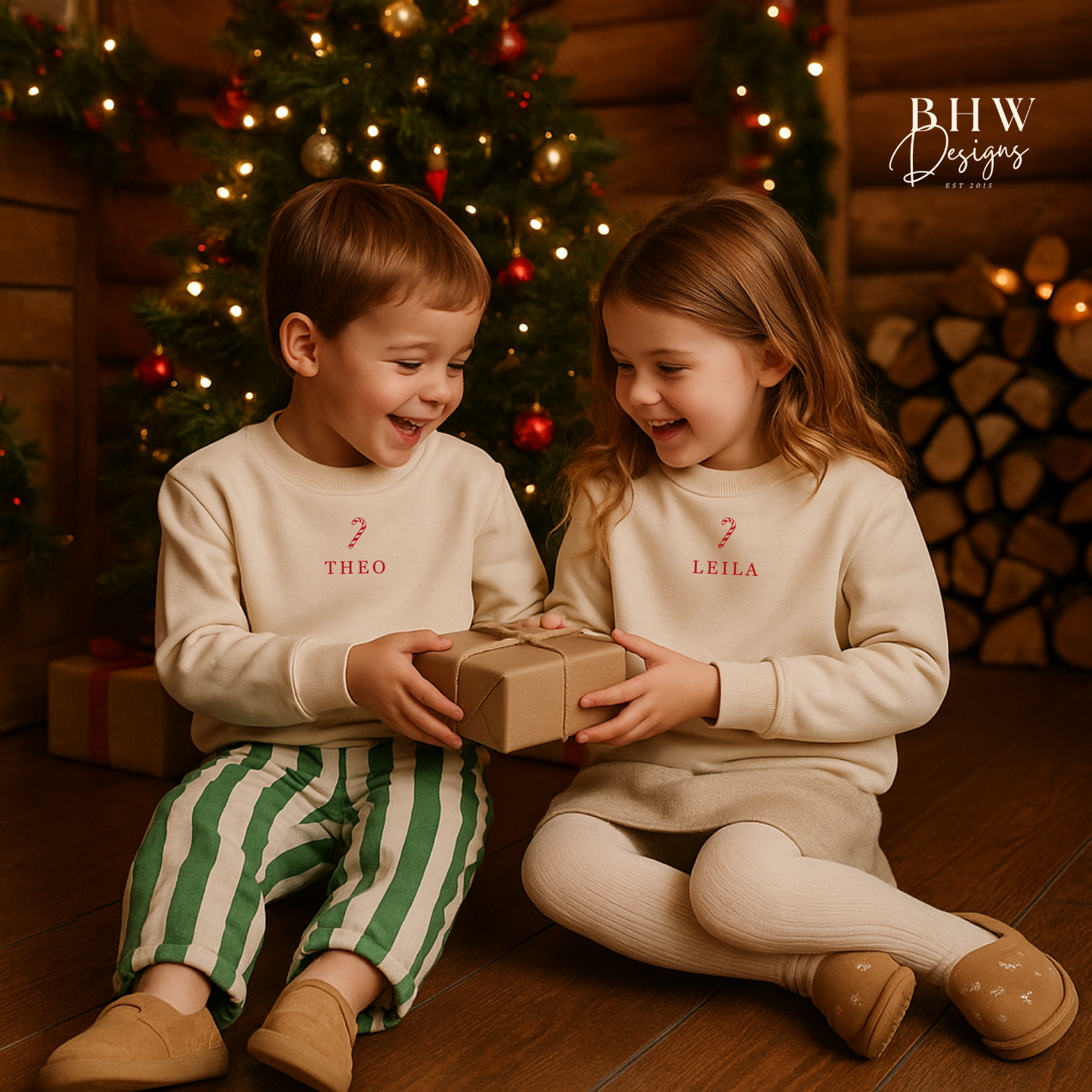 Two children in matching oat colour sweatshirt with a candy cane and Theo and Leila on the front in red