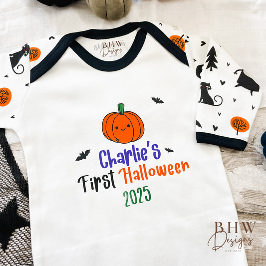 Baby onesie with Halloween design and 'Charlie's First Halloween 2025' text on a wooden surface.