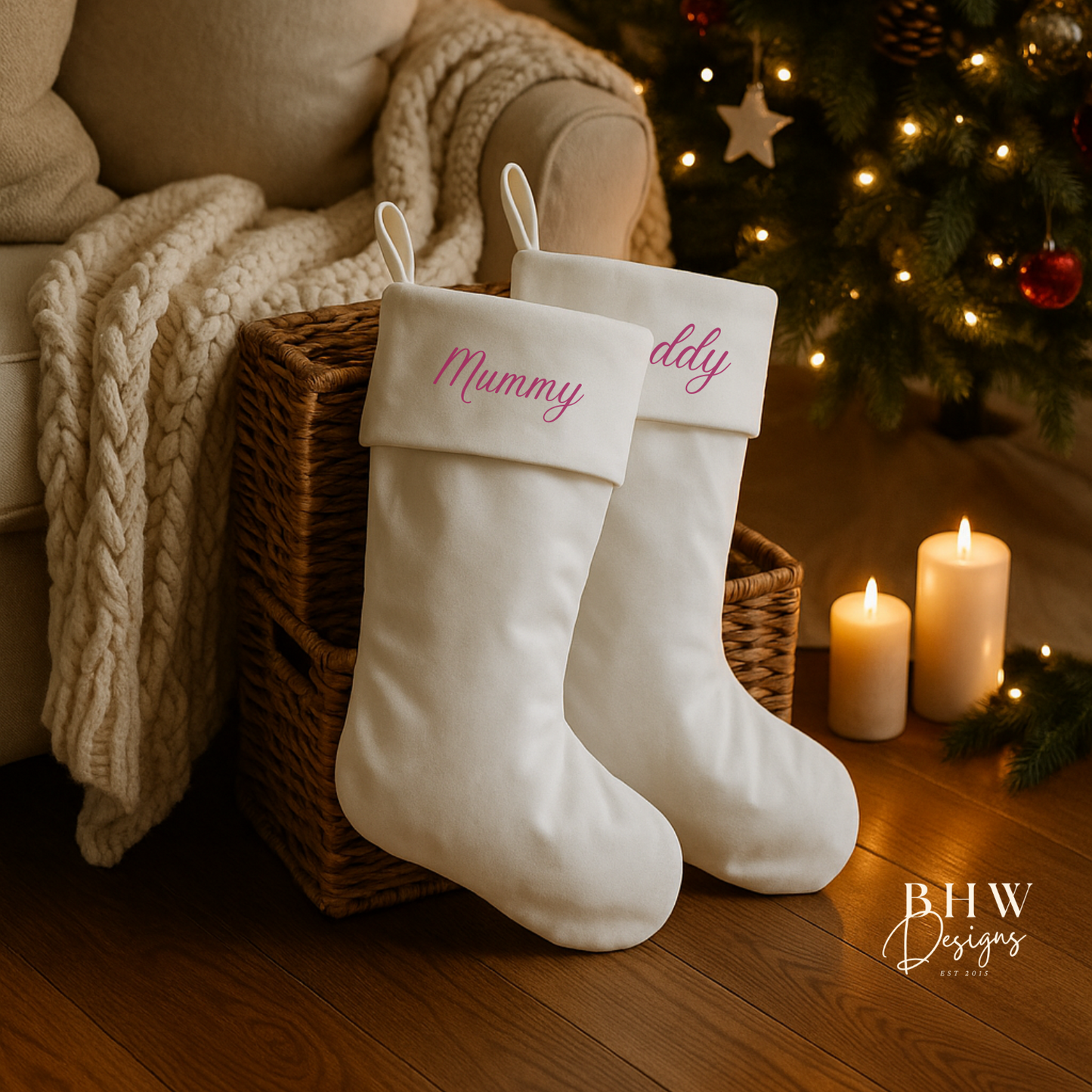 White stockings with 'Mummy' and 'Daddy' names in wine red text, placed in front of a decorated Christmas tree.