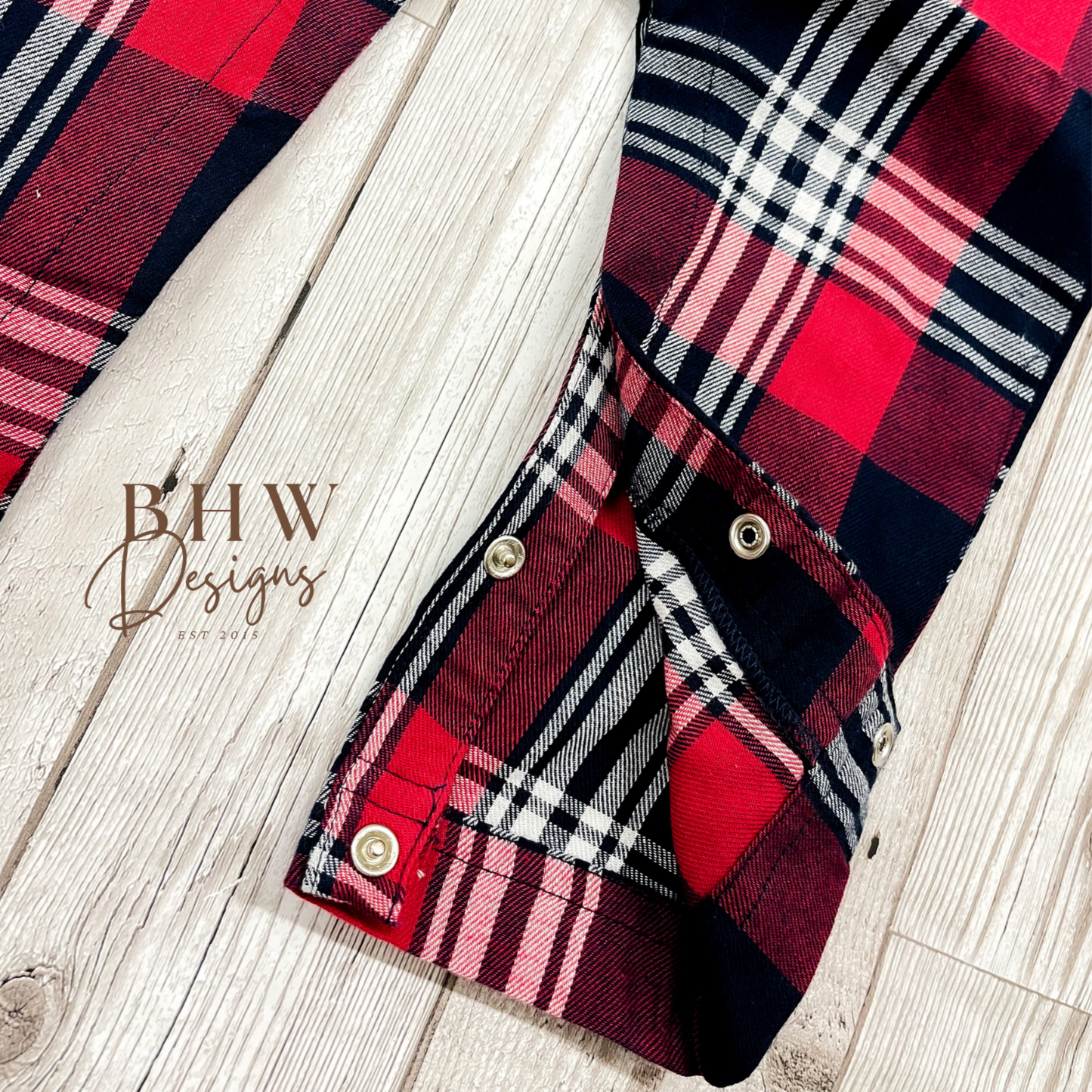 A tartan patterned romper onesie for babies, inside seam poppers