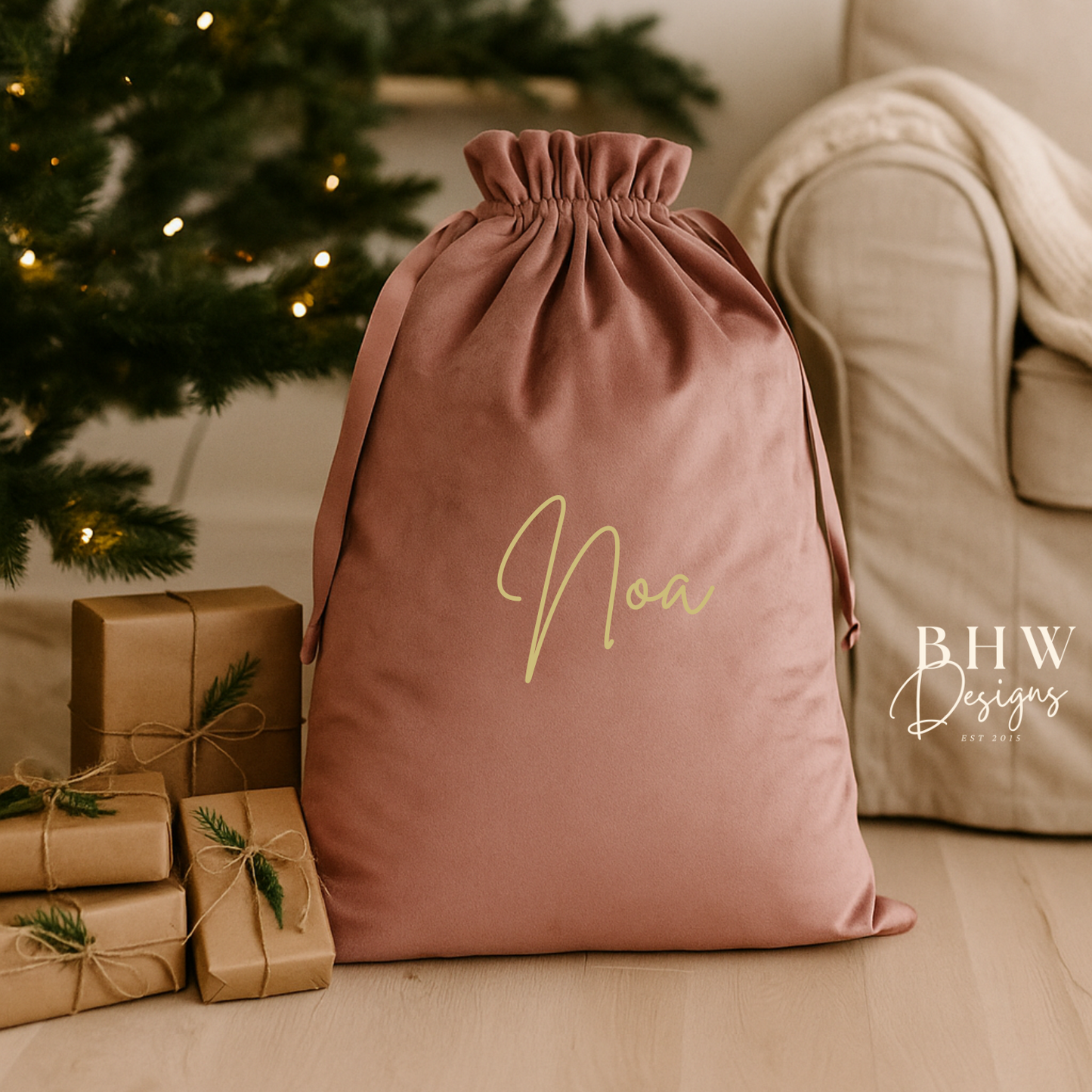 Pink drawstring bag with 'Noa' written on it, surrounded by Christmas decorations.