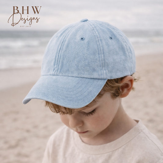 Child wearing a light blue cap on a beach
