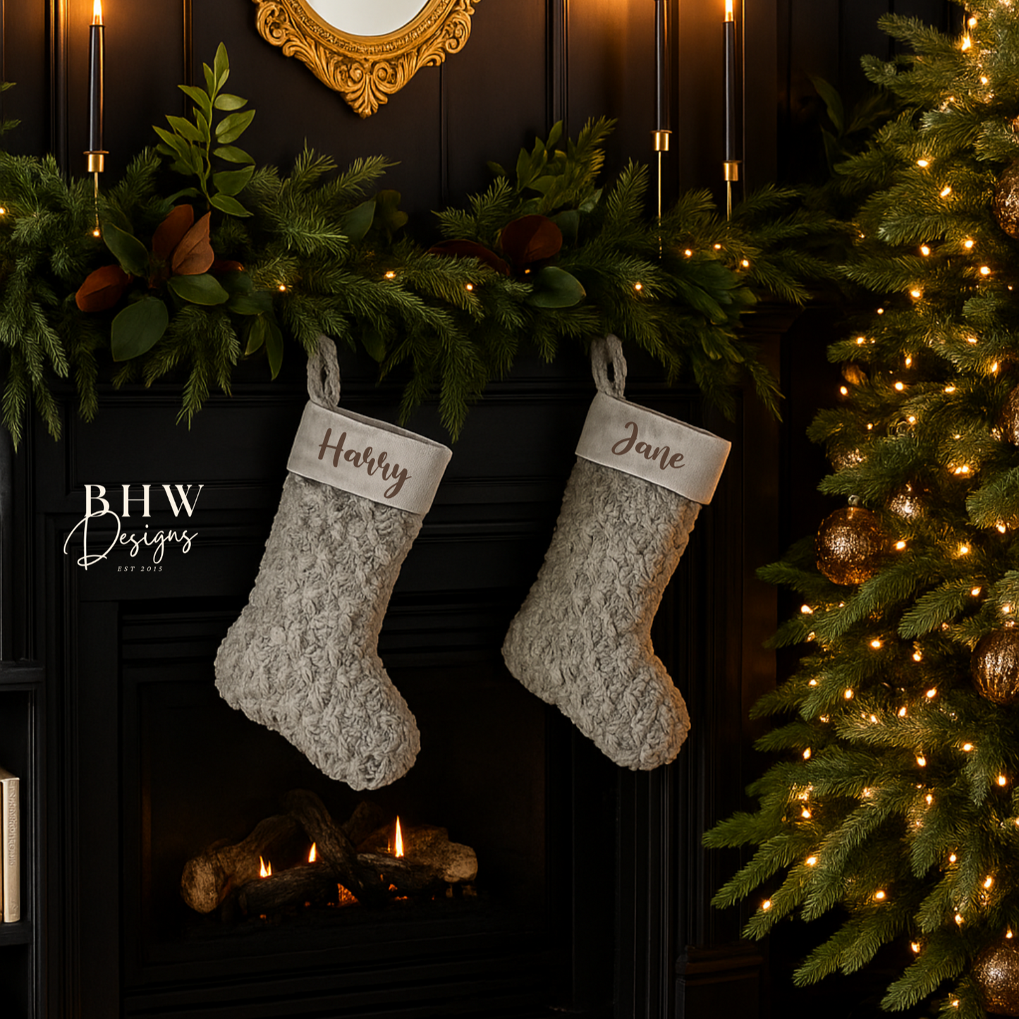 Two personalised Christmas stockings hanging above a fireplace with decorative lights and a tree.