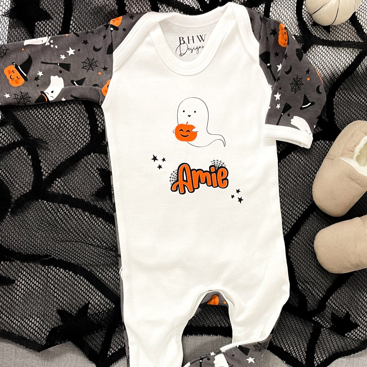 Halloween-themed baby romper with ghost and pumpkin design on a dark background