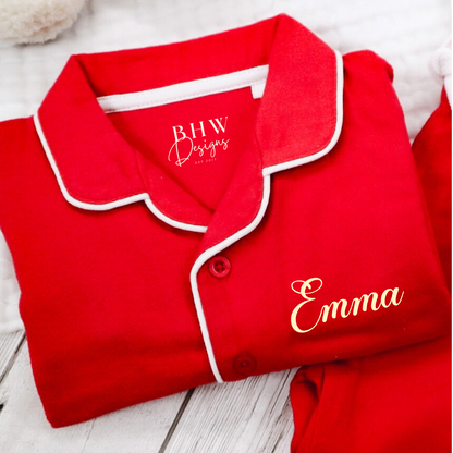 Folded red pyjama set with 'Emma' on it.