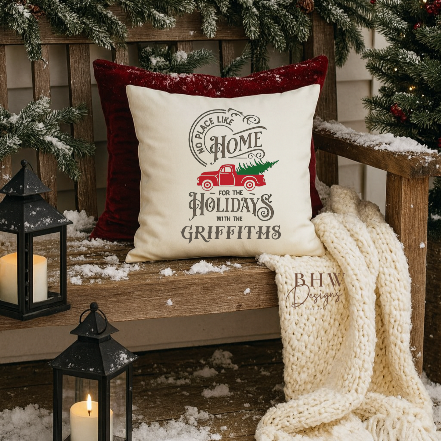 Decorative personalised family name no place like home christmas cushion. on a wooden bench with Christmas decorations.