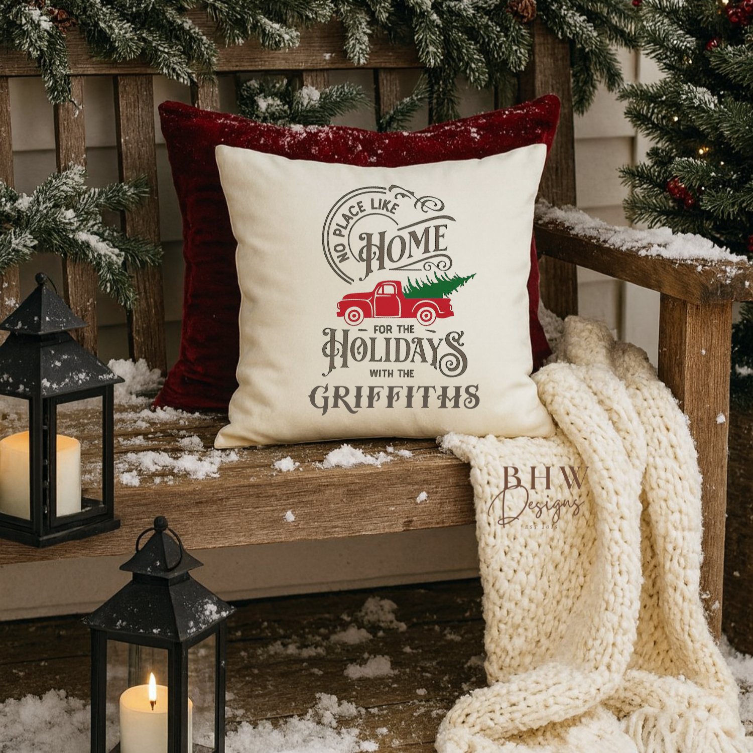 Decorative personalised family name no place like home christmas cushion. on a wooden bench with Christmas decorations.