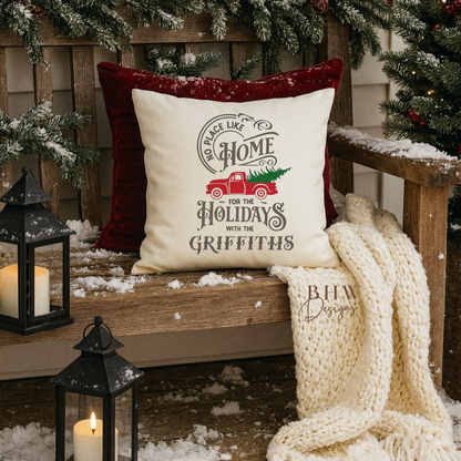 Decorative personalised family name no place like home christmas cushion. on a wooden bench with Christmas decorations.