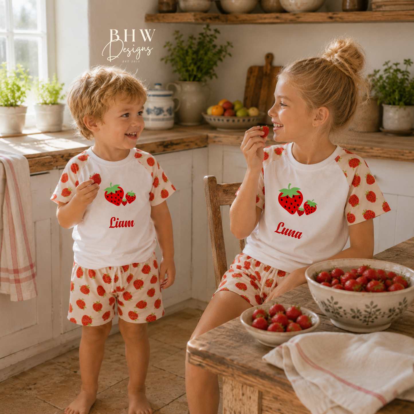 Two children in matching strawberry-themed outfits in a kitchen setting.