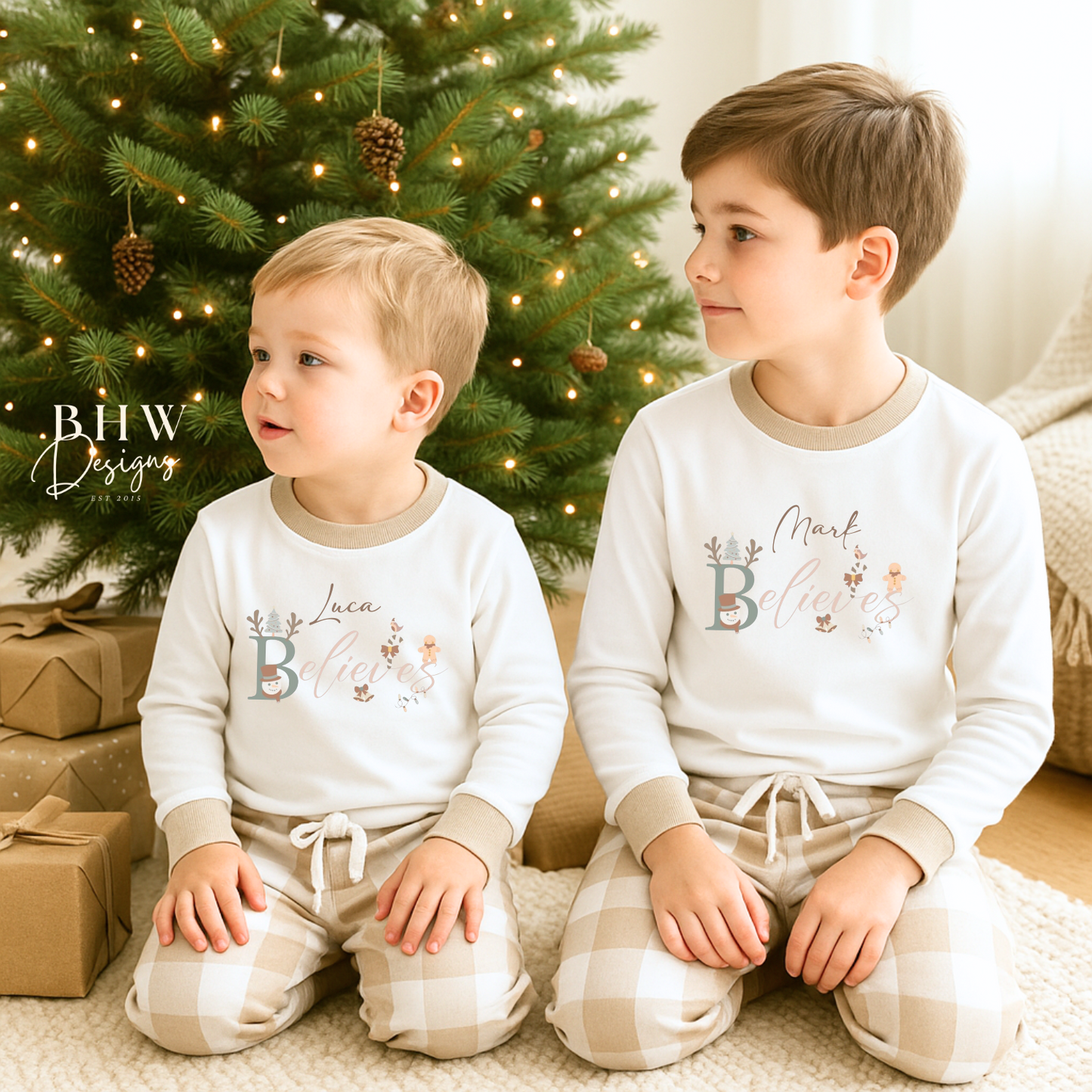 two children wearing a white long-sleeve top with beige cuffs personalised on the front with believes and beige and white check trousers