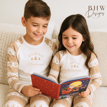 A boy and girl wearing a pair of beige and white fair isle print pyjama set with personalised name on the front. 
