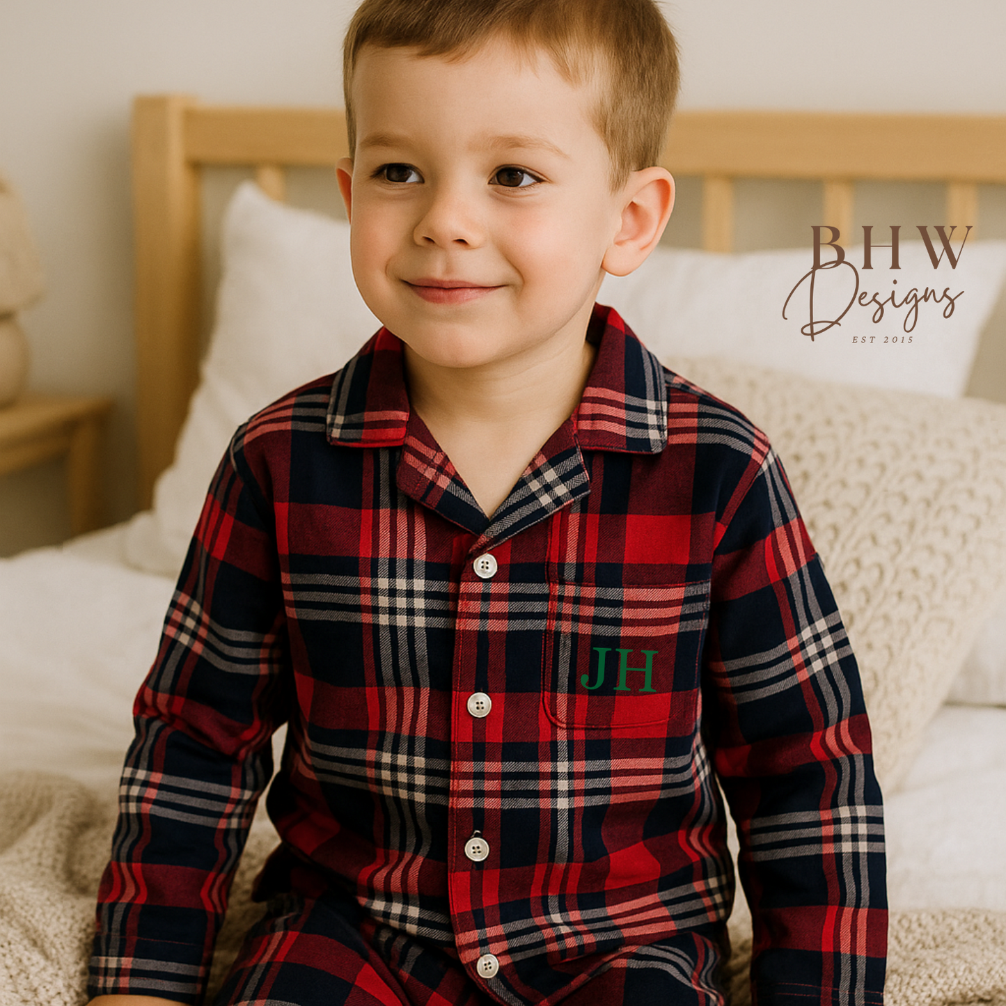 Child wearing a red and blue plaid pyjama set with 'JH' initials. 