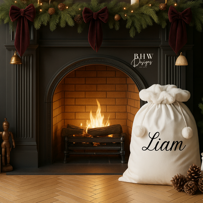 Decorative room with a a white Santa sack with white faux fur trim and pom pom's with Liam on the front in black