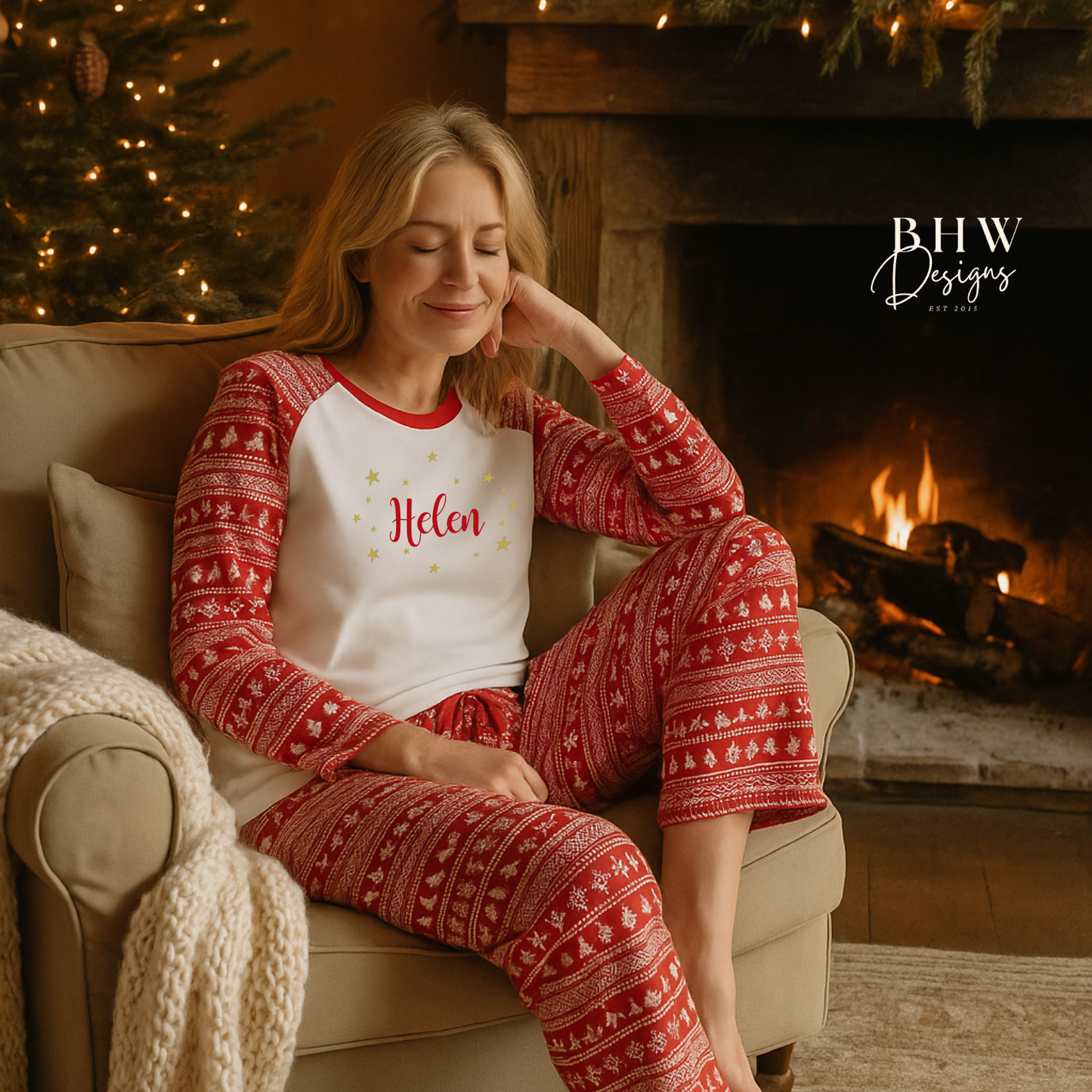 Woman wearA pair of women's Christmas pyjamas with a red and white Fair Isle print, featuring the word 'Helen' on the front and adorned with gold stars.