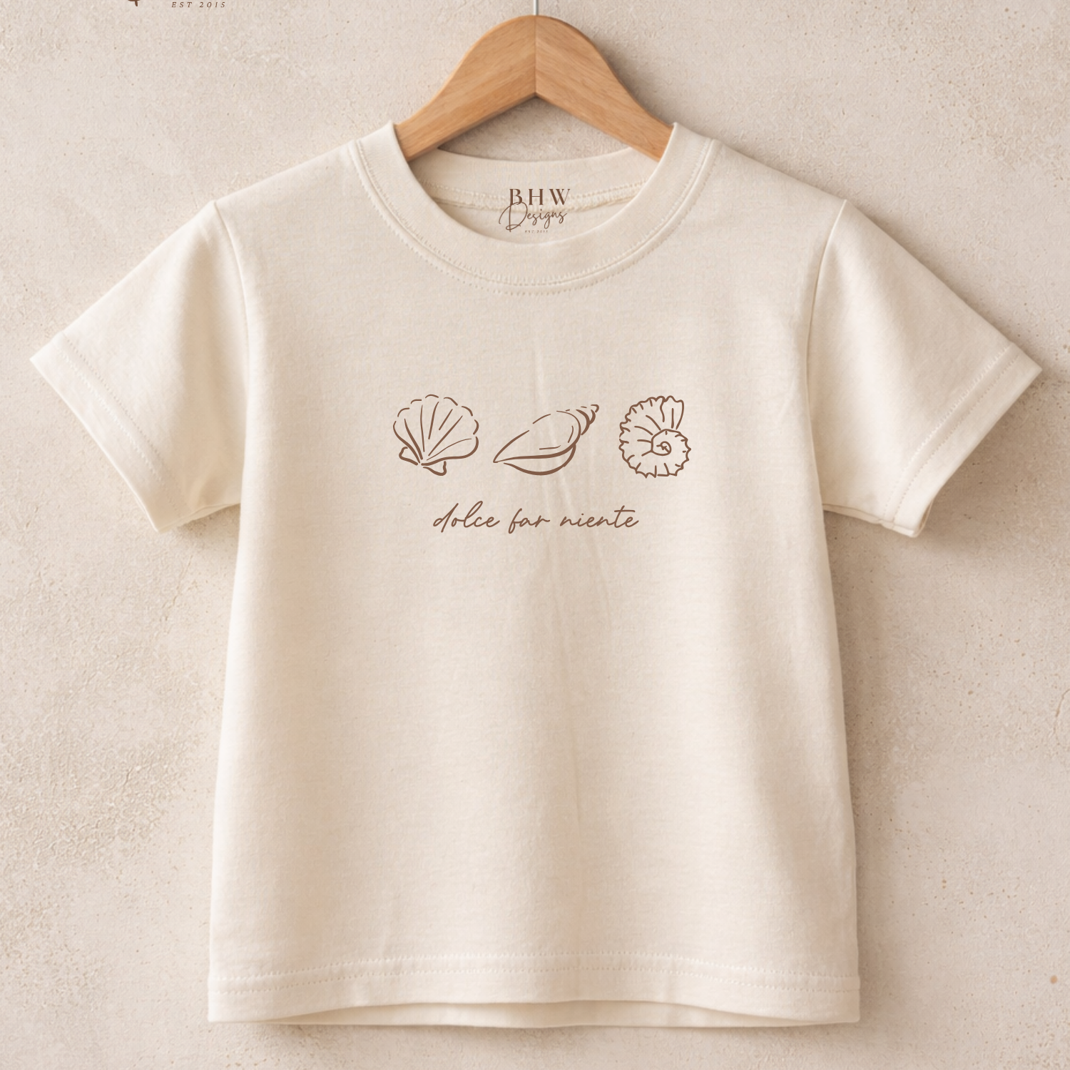 Beige t-shirt with shell designs and text on a beige background,