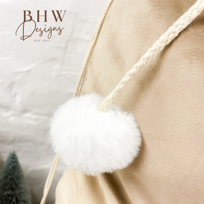 Close-up of a beige santa sack with a white fluffy pom-pom 