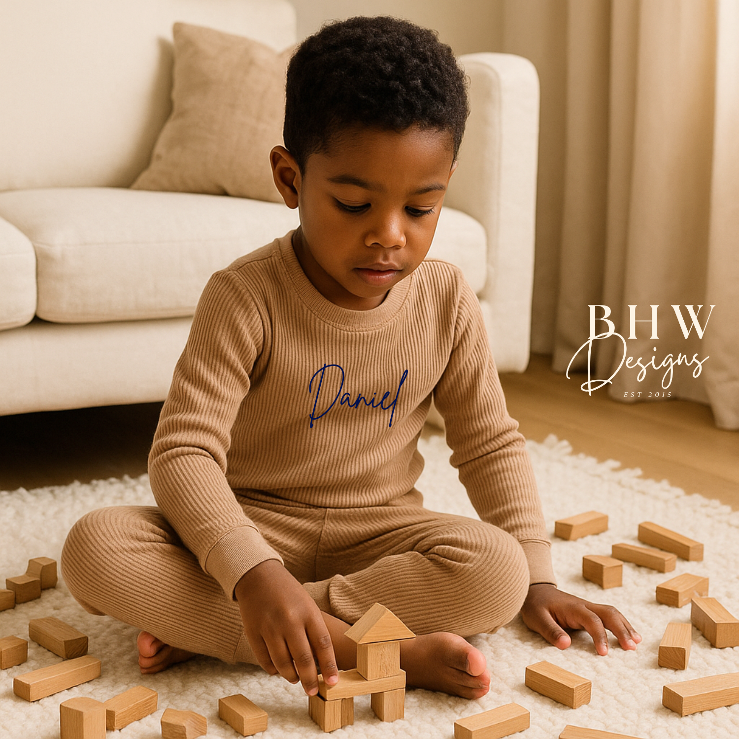 Child playing  wearing a beige outfit with 'Daniel' printed on it.