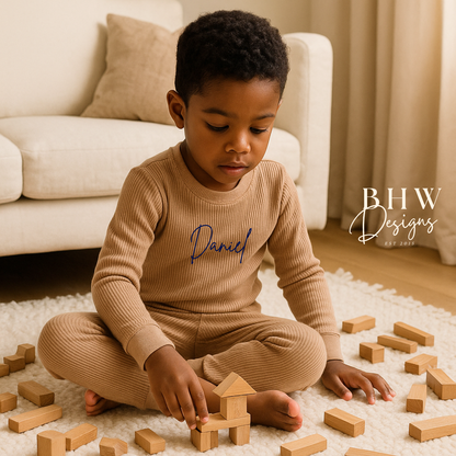 Child playing  wearing a beige outfit with 'Daniel' printed on it.
