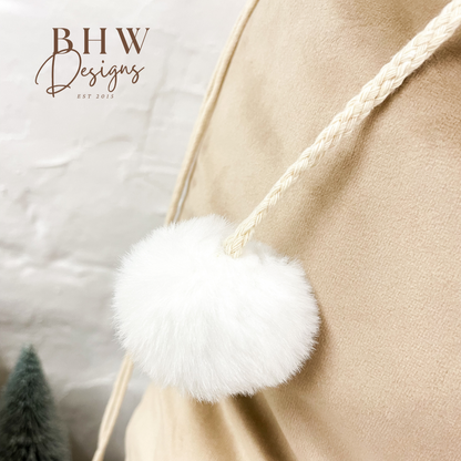 Close-up of a beige sack with a white fluffy pom-pom 