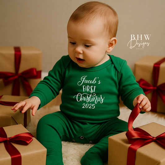 Baby in a green outfit with 'Jacob's First Christmas 2025' text, on the front in white surrounded by gift boxes with red ribbons.