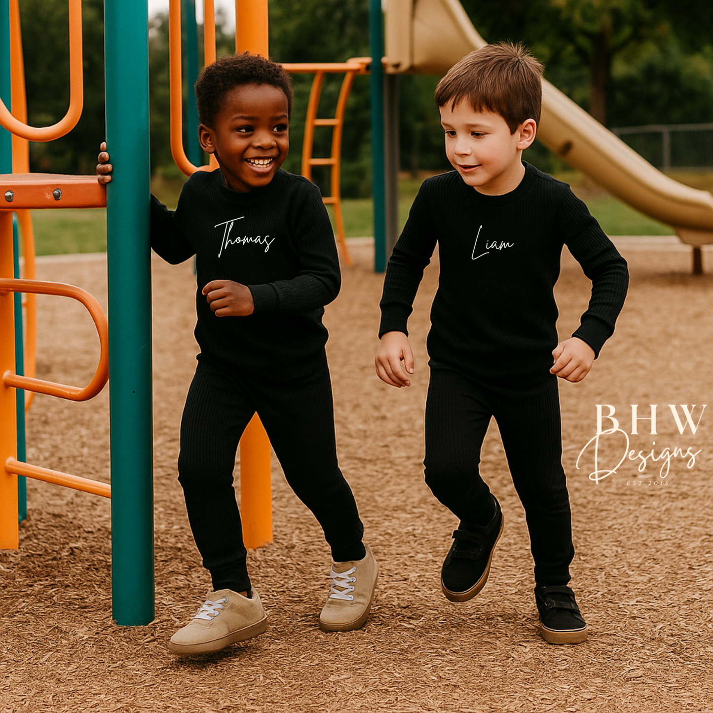 Two children in ribbed black outfits personalised with names on. 