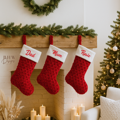 Three red Christmas stockings hanging above a fireplace with personalised names.