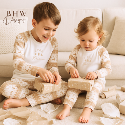 A boy and girl wearing a pair of beige and white fair isle print pyjama set with personalised name on the front. 