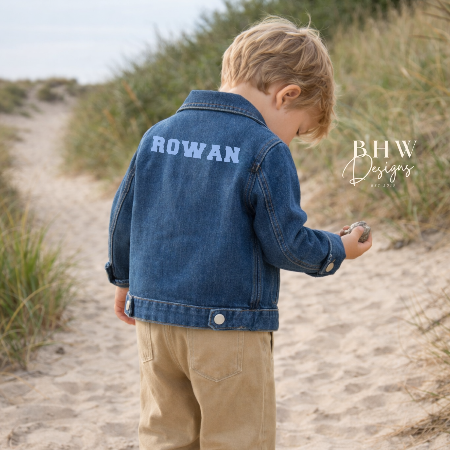 Child wearing a blue denim jacket with 'ROWAN' on the back in baby blue 
