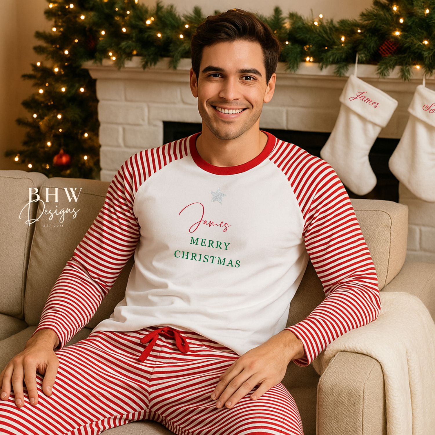 Man wearing red and white striped pyjamas with 'James, Merry Christmas' text, sitting on a couch in a festive living room.