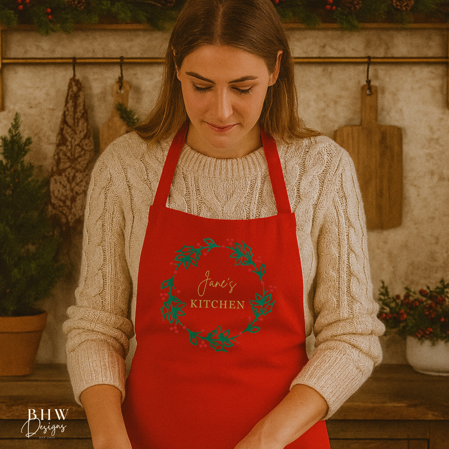 Woman in a personalised red apron with a Christmas design rolling out dough in a kitchen.