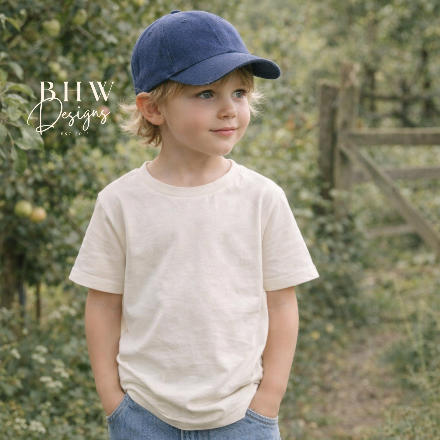 Young boy wearing a navy cap and beige shirt in an outdoor setting 