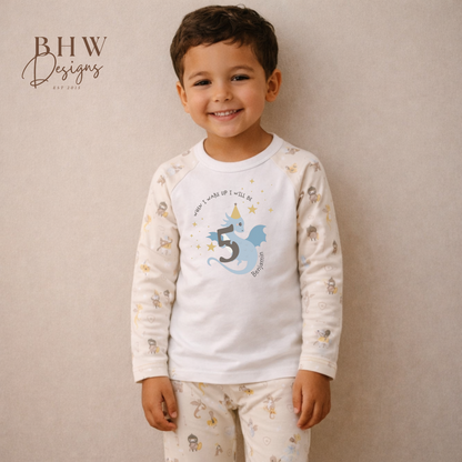 Child wearing a white long-sleeve shirt with a number 5 design and matching pants, standing against a plain background.