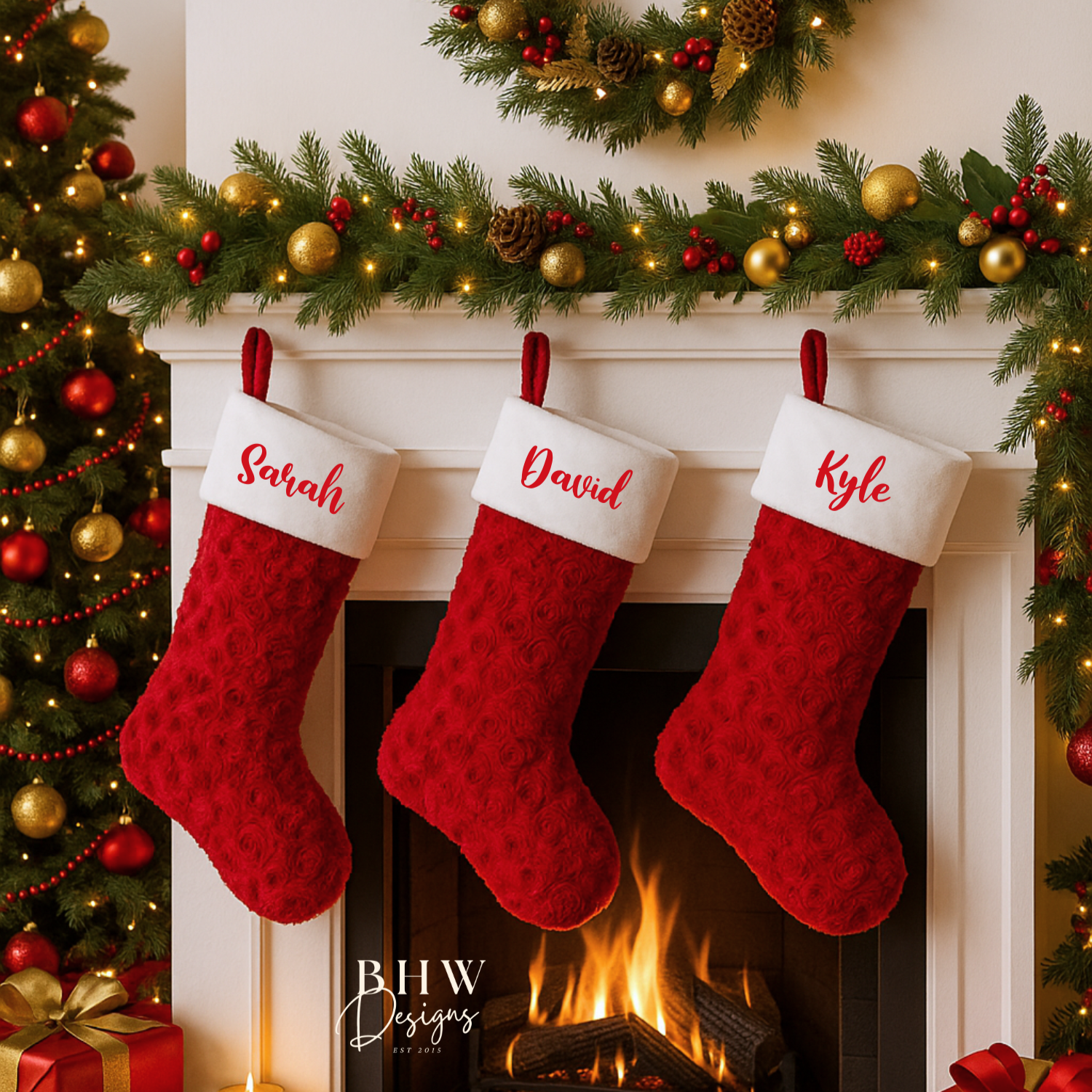 Three red Christmas stockings with names on a fireplace mantel decorated with festive garlands and lights.