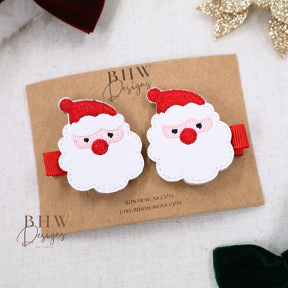 Santa Claus-themed hair clips on a brown card with 'BHW Designs' branding, surrounded by decorative bows.