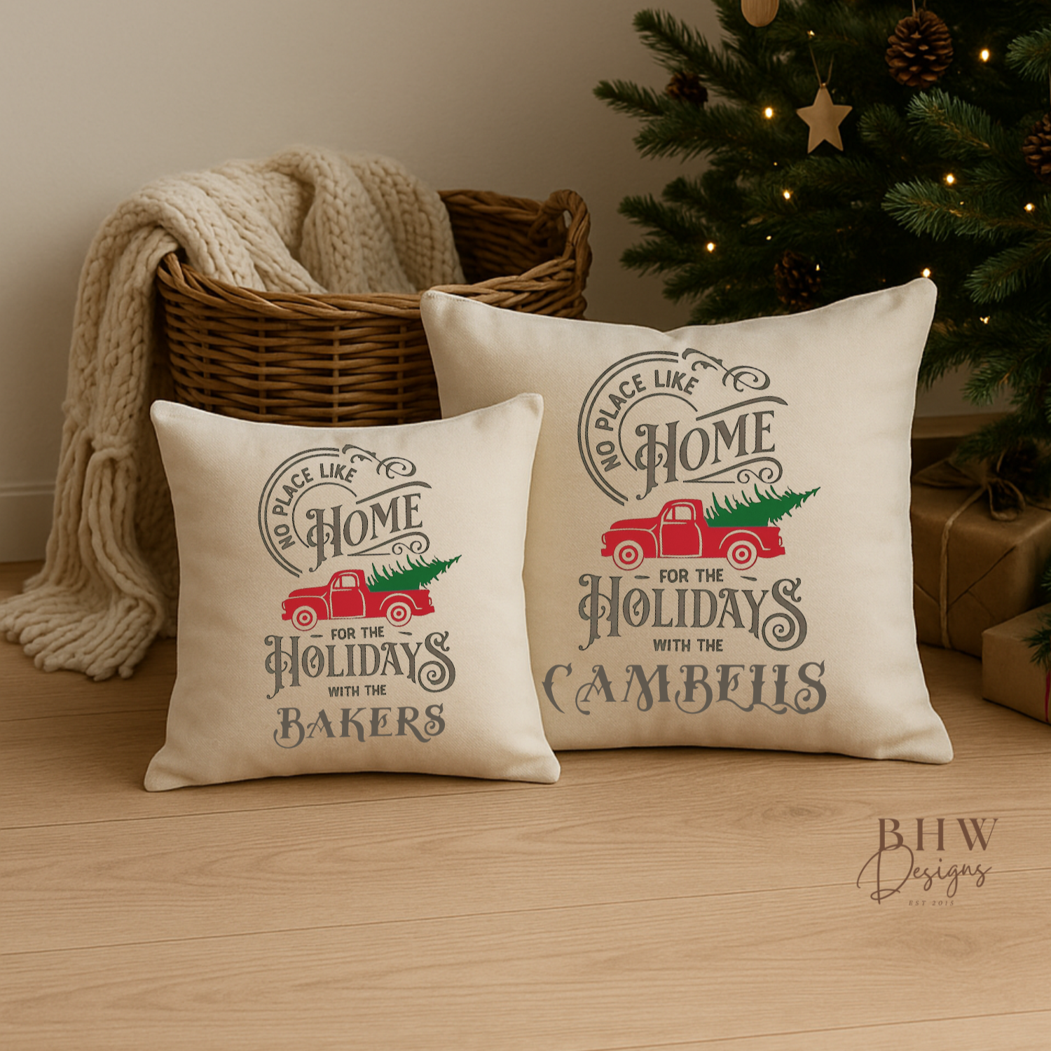 Two decorative personalised family name no place like home christmas cushion on a wooden floor with a Christmas tree in the background.