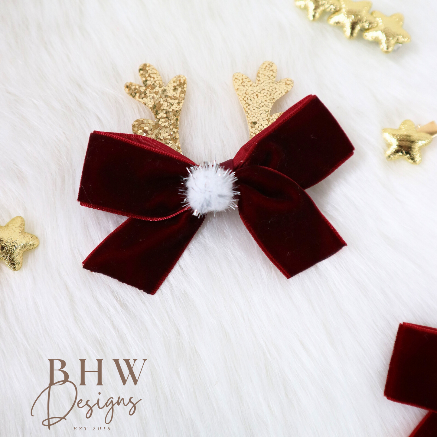 Red velvet bow with gold deer antlers on a white background