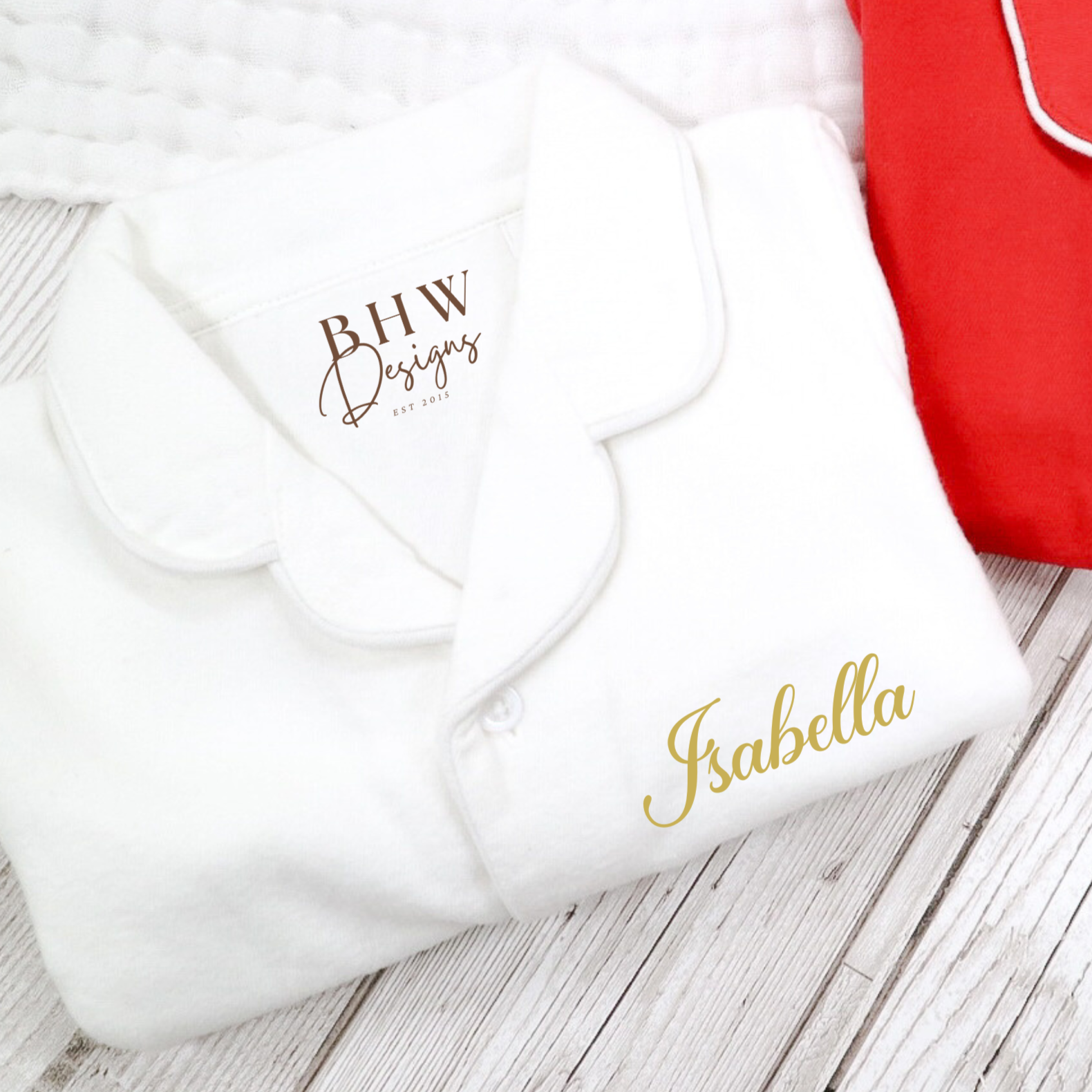 White pyjamas folded with Isabella printed in gold 