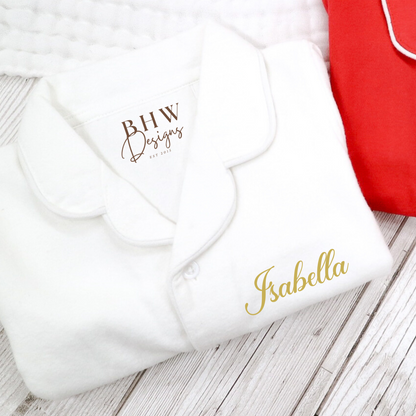 White pyjamas folded with Isabella printed in gold 