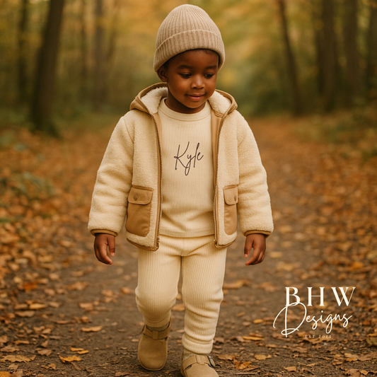 Child in a cream personalised outfit walking on a forest path.