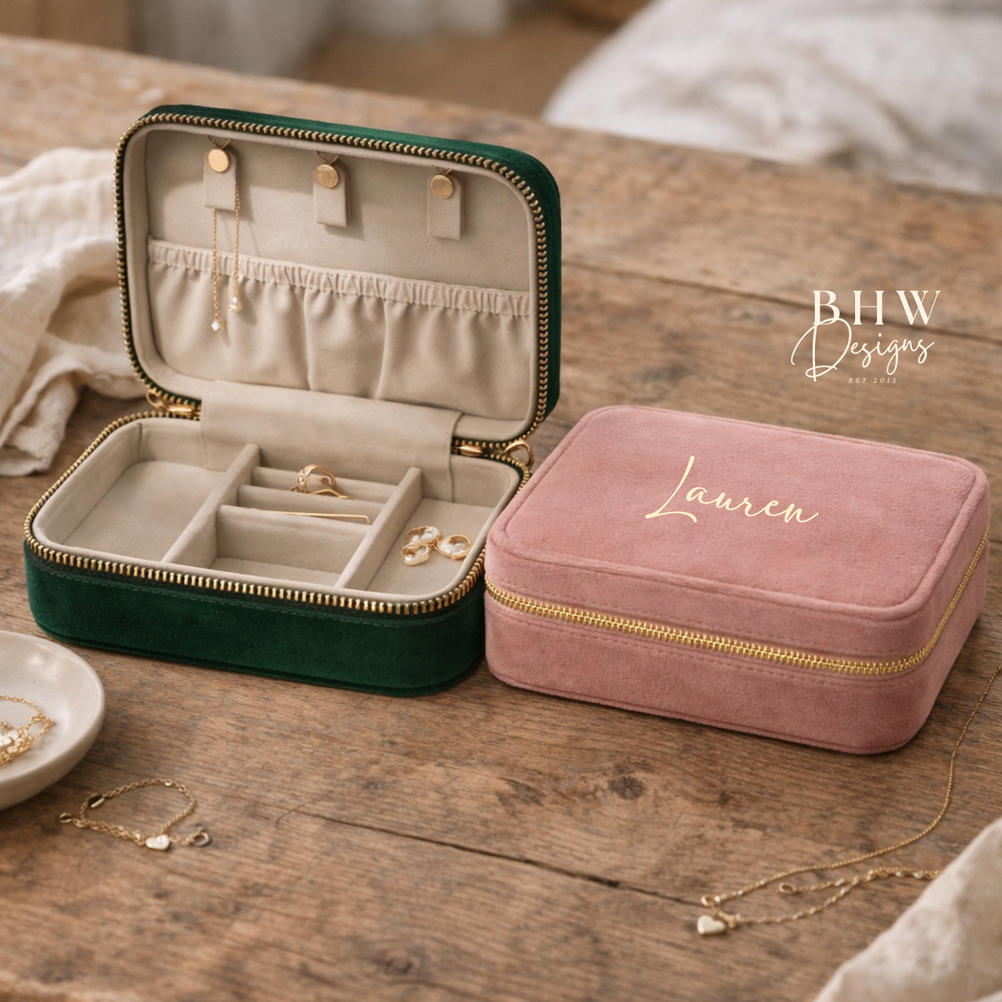 Two jewellery boxes, one green and one pink, on a wooden surface with jewellery inside.