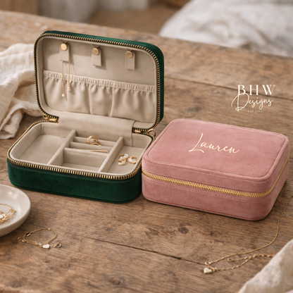 Two jewellery boxes, one green and one pink, on a wooden surface with jewellery inside.