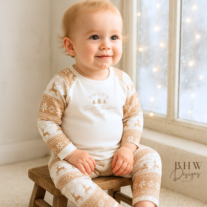 A baby wearing a pair of beige and white fair isle print pyjama set with personalised name on the front. room.