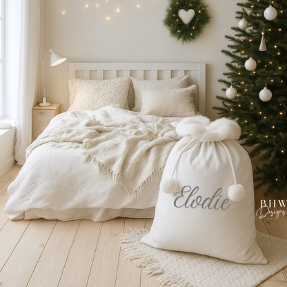 Cozy bedroom with a white Santa sack with white faux fur trim and pom pom's with Elodie on the front in grey