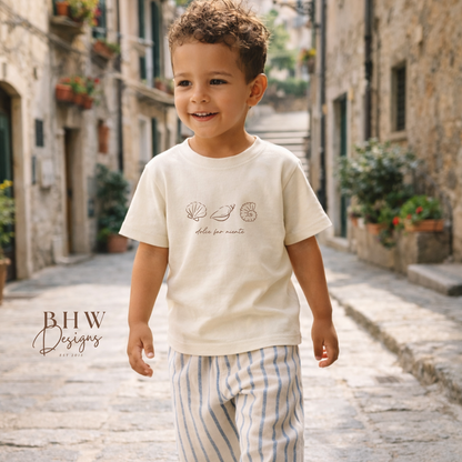 Child walking down a stone street in an old town, wearing a white t-shirt and striped pants.